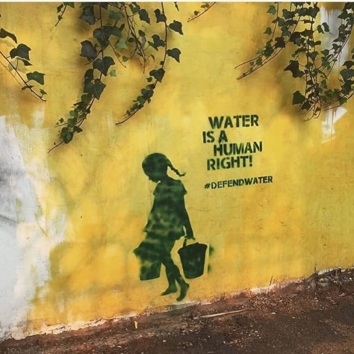 Community members holding #DefendWater campaign signage